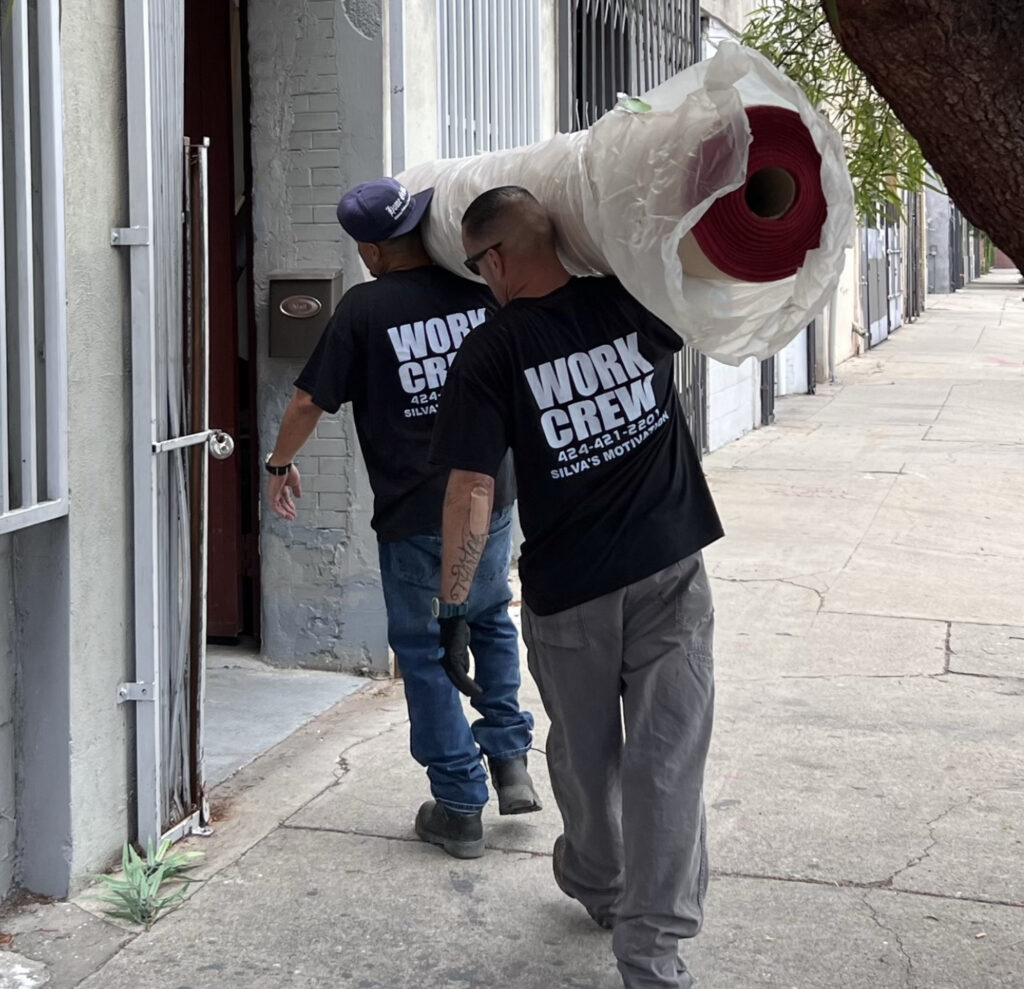 work crew pic 2 men carrying carpet